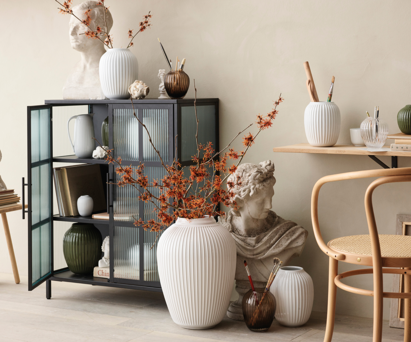 Ribbed vases with flowering branches and paintbrushes.