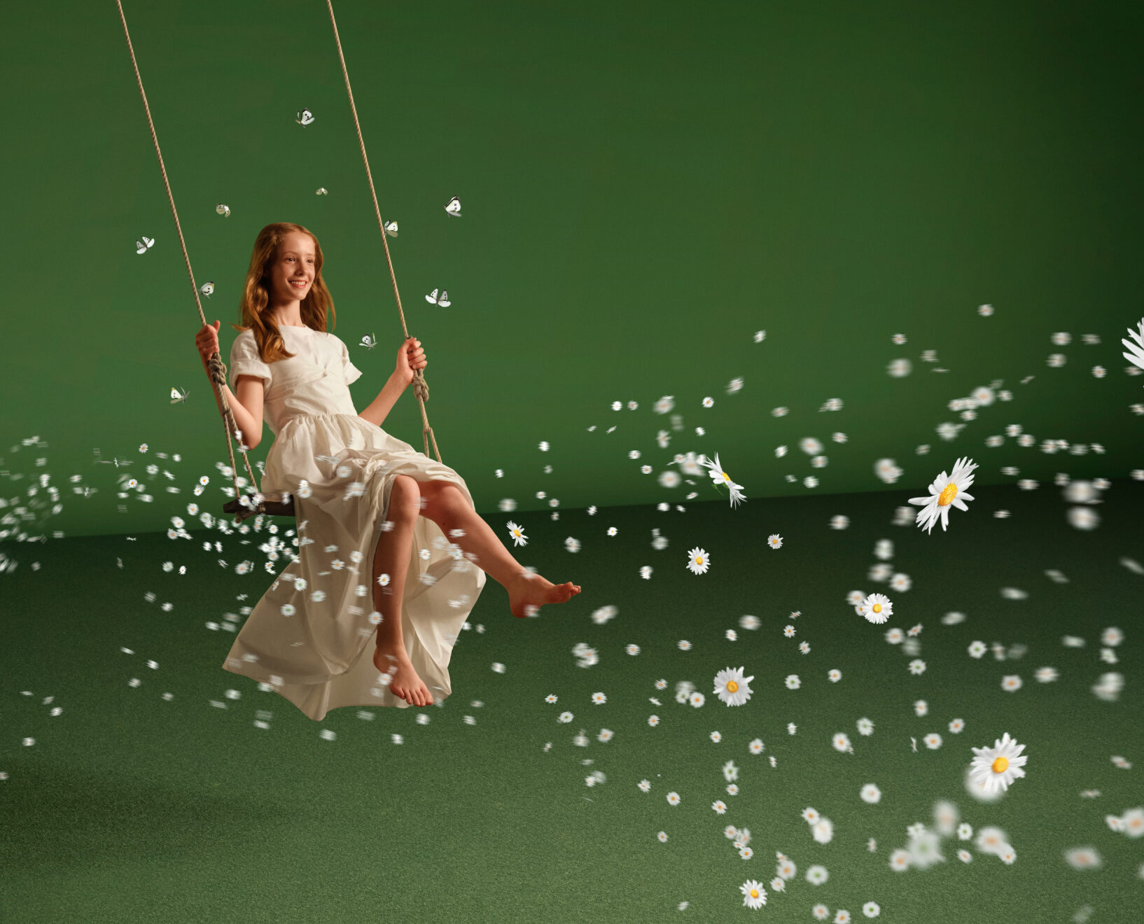 A woman in a white dress on a swing, surrounded by floating daisies against a green background.