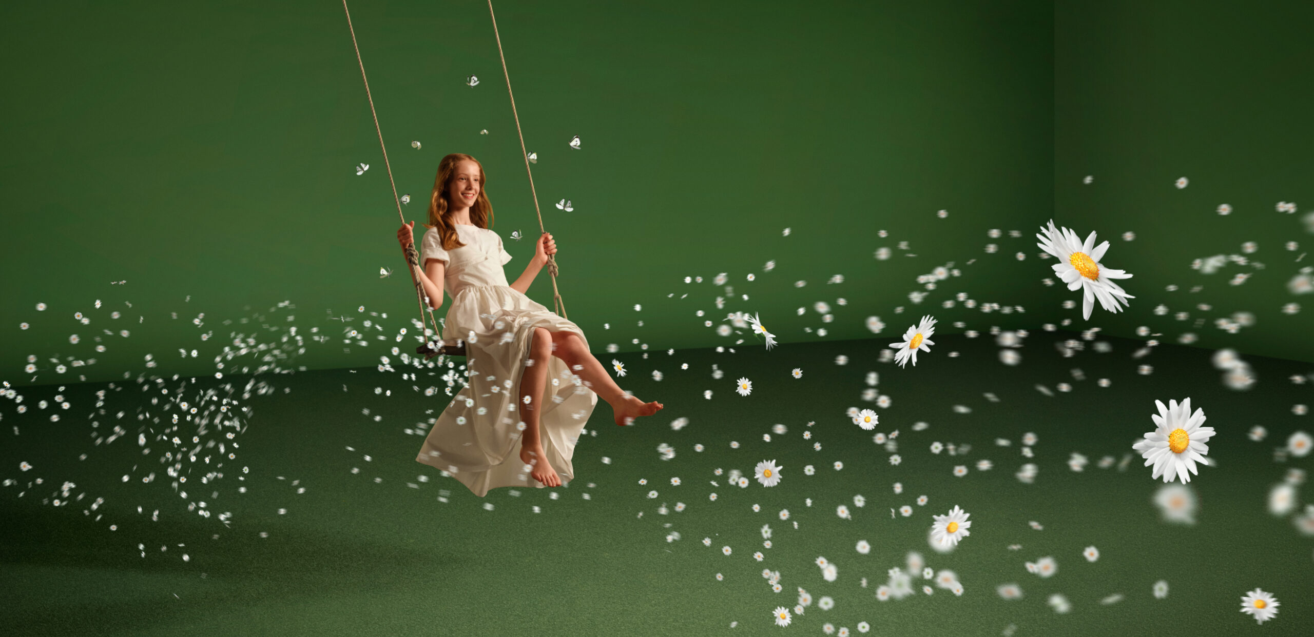 A woman in a white dress on a swing, surrounded by floating daisies against a green background.
