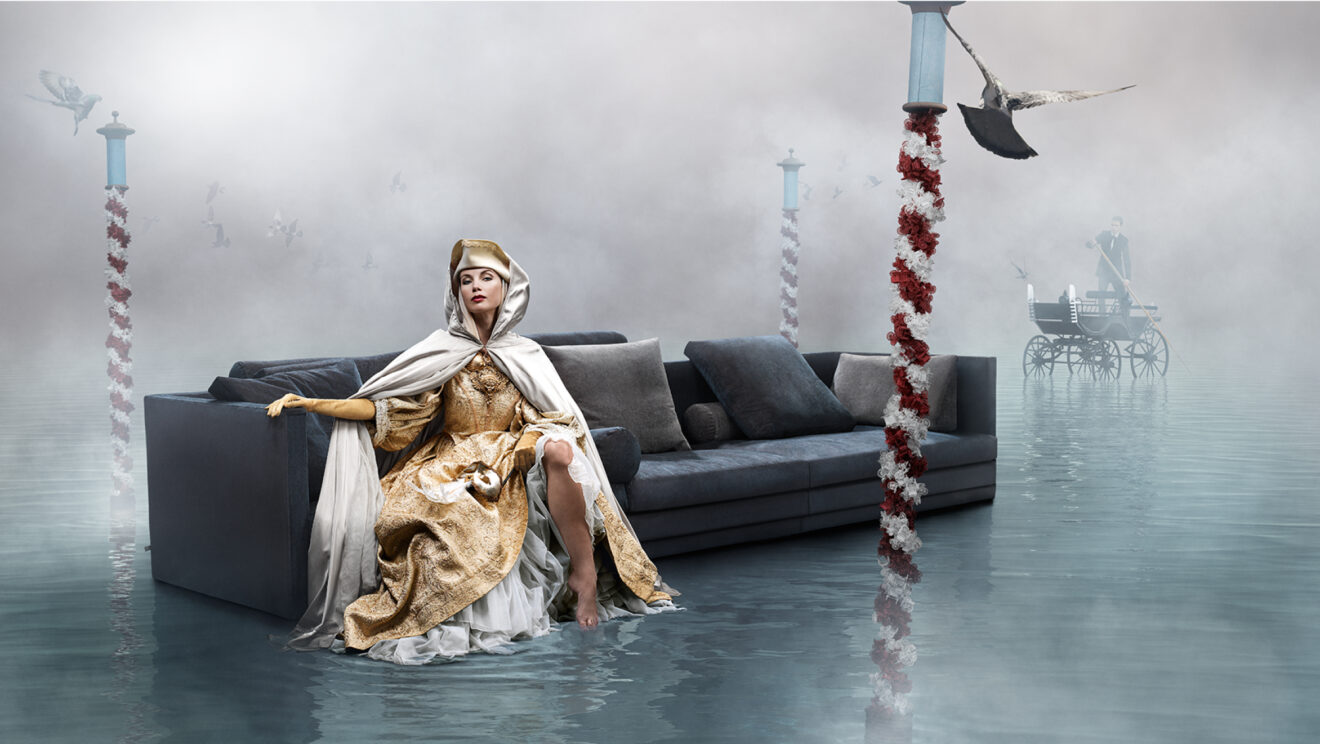 A woman sitting on a Eilersen sofa in the water.