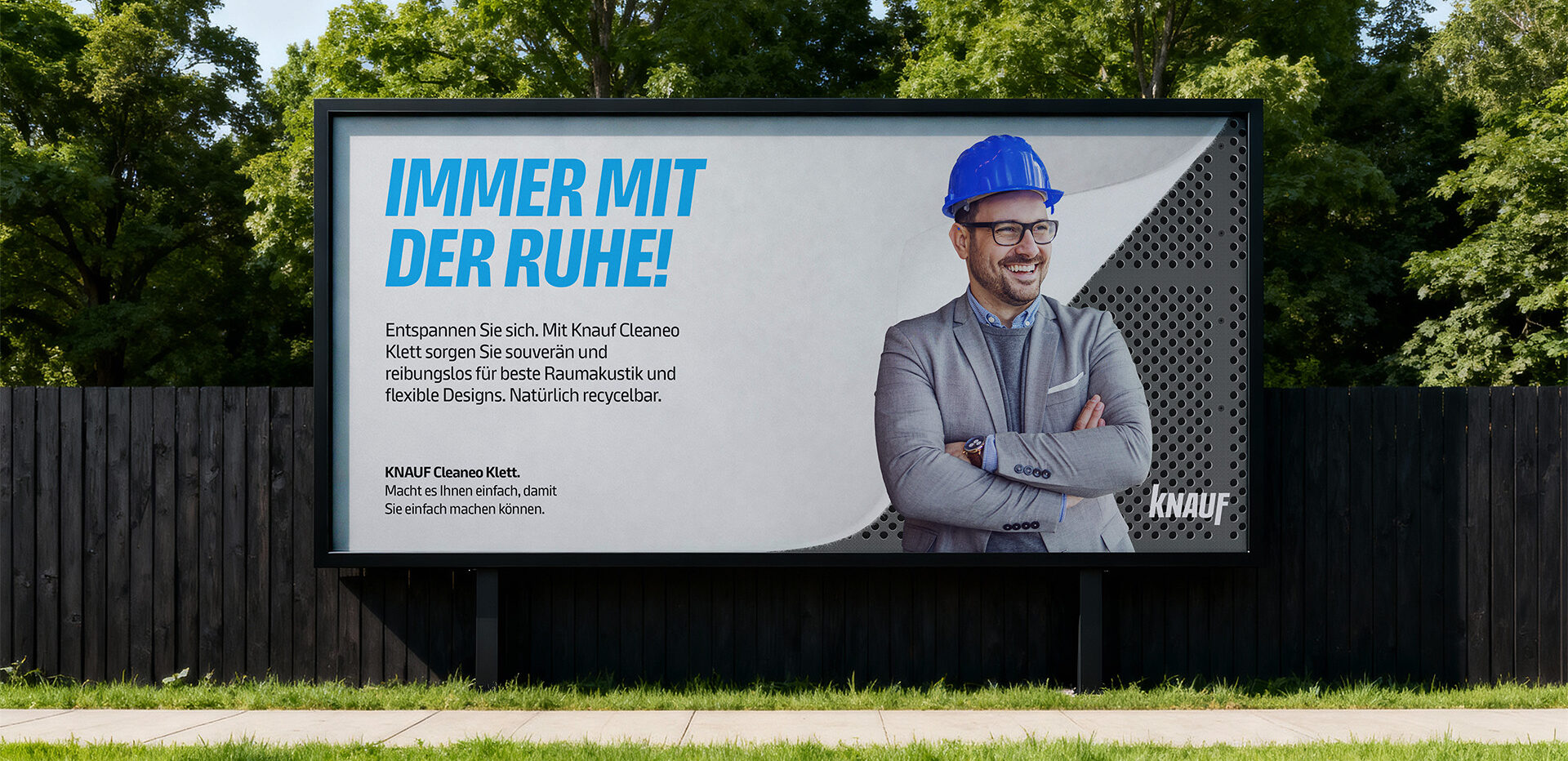 Knauf billboard featuring a smiling man in a blue hard hat.